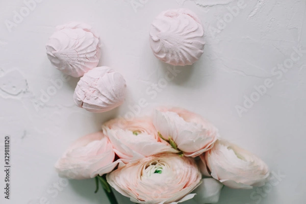 Fototapeta Spring wallpaper. Pink rose flowers and marshmallows on a white background. Flowers composition. Flat lay, top view, copy space. 