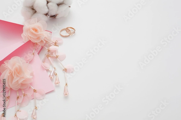 Fototapeta Wedding text background, white, decorated with pink invitation envelopes, top view, with copy space. The concept of a wedding date or a gentle background for the bride.