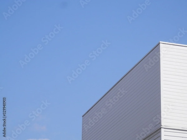 Fototapeta 白い壁の建物上部と青空