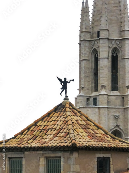 Obraz Girona, Spain. Weathervane "trumpeter" with The Collegiate Church of Sant Feliu on the backward plane,  isolated on white background