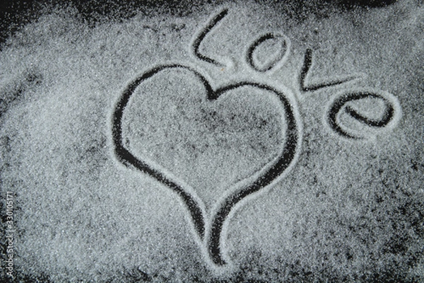 Obraz heart and the word love are drawn by sugar, on a black background, Valentine's Day