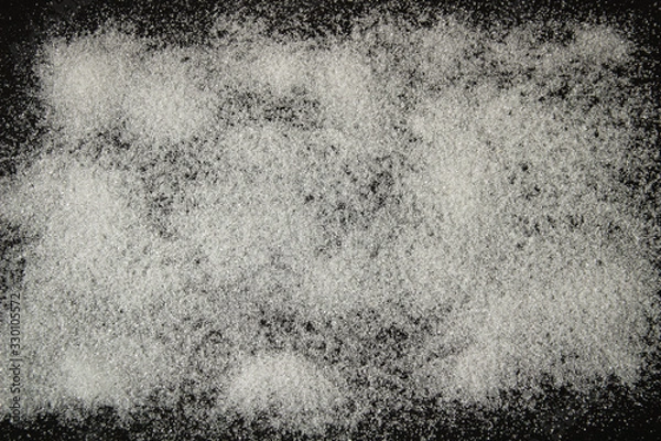 Obraz white sugar sprinkled on a black background