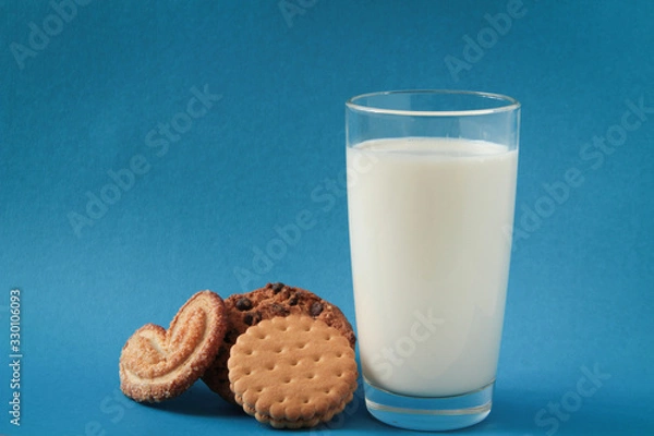Obraz cookies and a glass with milk. chocolate oatmeal cookies, puff and lingering. on a blue background.