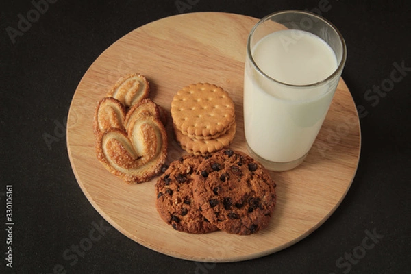 Obraz chocolate chip cookies and glass of milk, on a wooden board