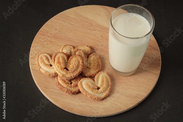 Obraz glass of milk and cookies in the form of hearts, on a wooden board