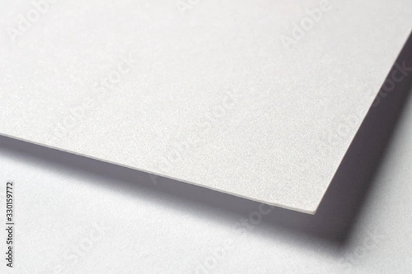 Fototapeta Blank textured design paper corner macro view with selective focus on white as template for logo presentation, embossing etc.
