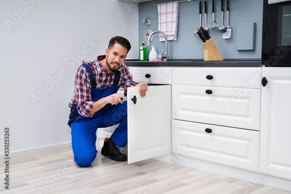 Obraz Man In Overall Repairing Cabinet