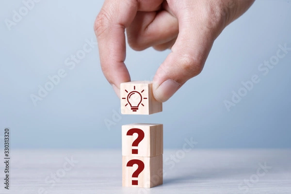 Fototapeta 3 Wood Cubices with sign question mark symbol and Light Blub on wood table Blue tone.