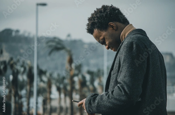 Obraz portrait of young man in the street with a smartphone