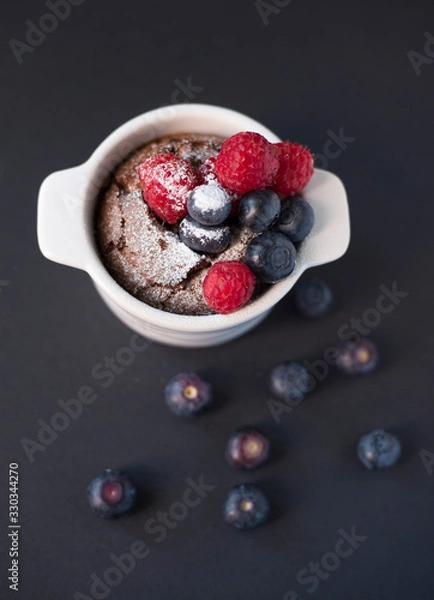 Fototapeta Chocolate suffle with blackberries and raspberries on the top