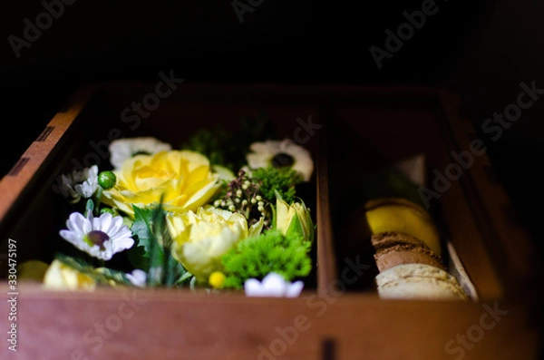 Fototapeta flowers and macaroons in a gift box made of plywood
