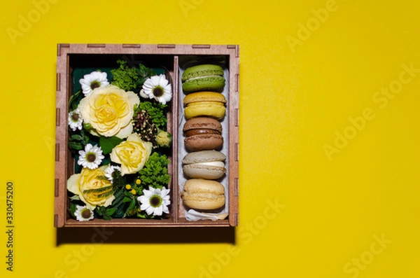 Fototapeta flowers and macaroons in a gift box made of plywood