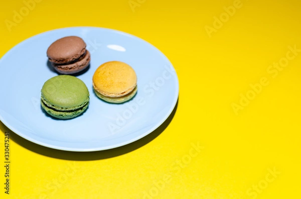 Fototapeta colored macaroons on a blue plate