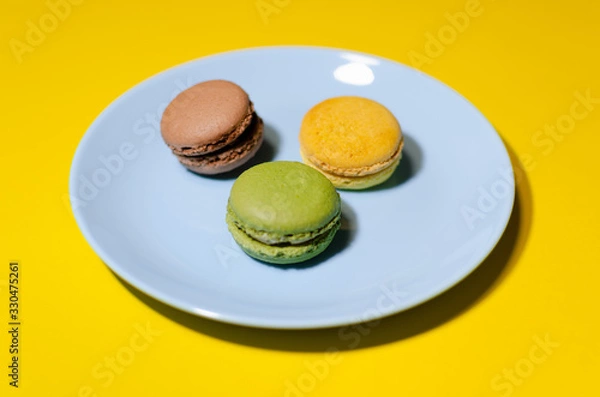Fototapeta colored macaroons on a blue plate