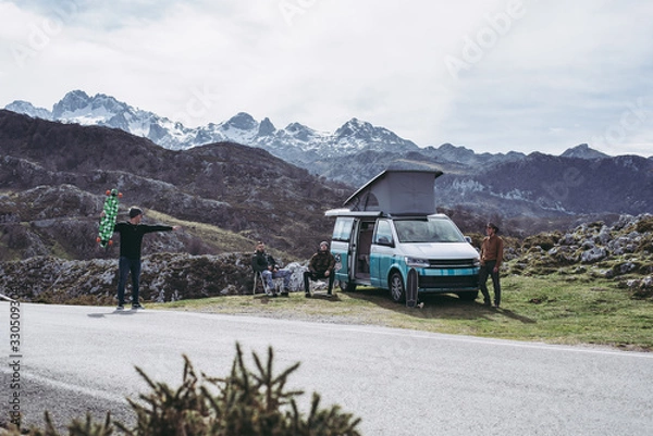 Fototapeta Campervan with friends skating in the mountains having fun open plan summer 