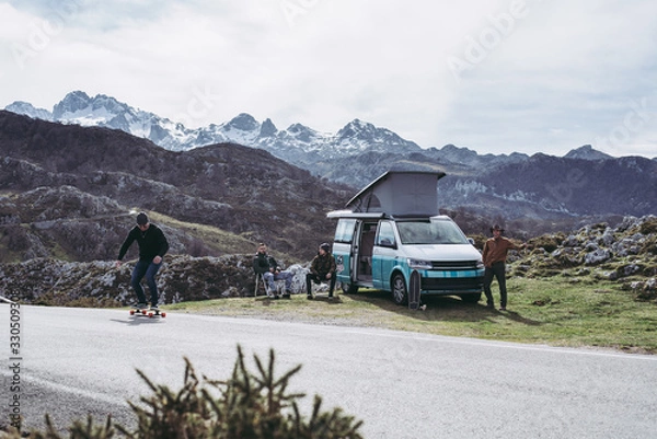 Fototapeta Campervan with friends skating in the mountains having fun open plan summer 