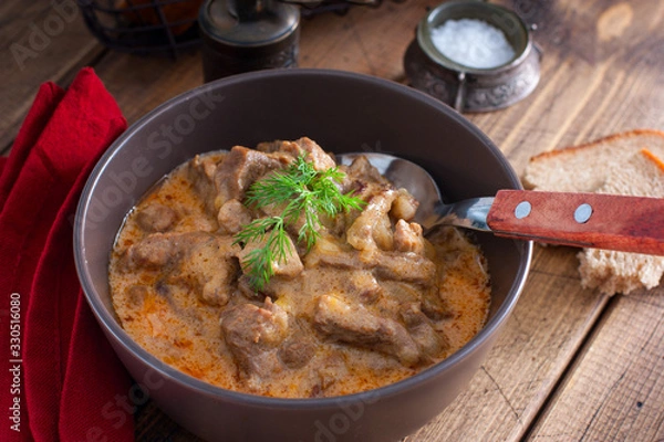 Obraz Traditional beef stroganoff in a ceramic bowl on a wooden table, selective focus
