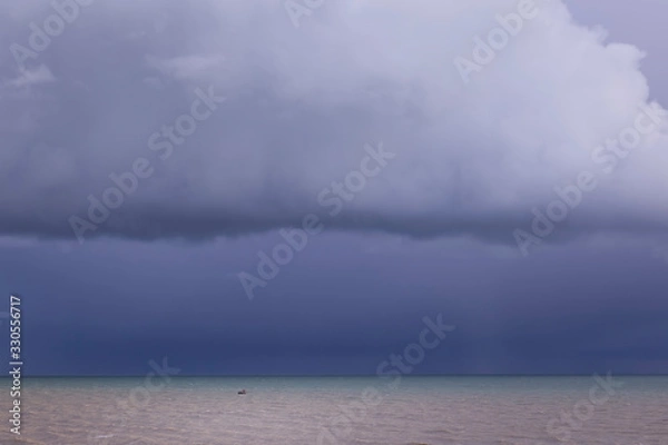 Obraz small boat under moody clouds