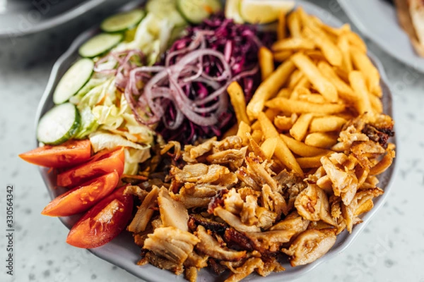 Fototapeta Doner Kebab on plate with vegetables fries and souce, grilled meat on plate