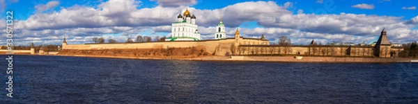 Fototapeta Spring panorama of an old medieval fortress standing on the river Bank. Pskov, Russia.