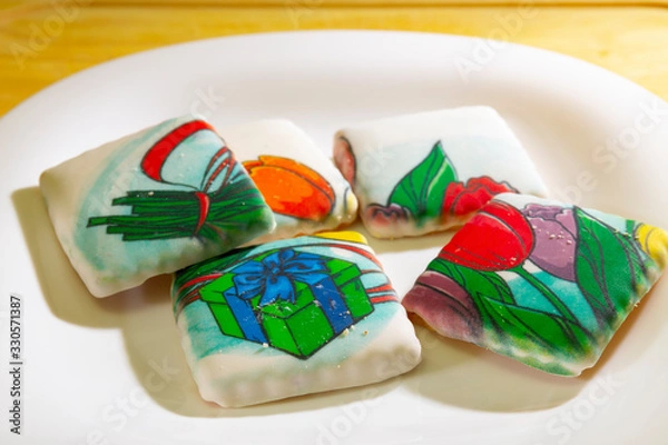 Fototapeta Cookies covered with icing are on the plate.