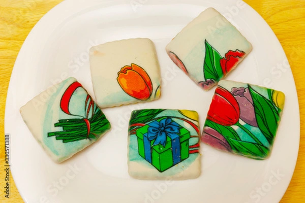 Fototapeta Cookies covered with icing are on the plate.