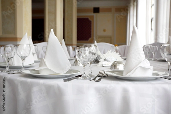 Obraz Place settings on an elegant, white dining table in a restaurant