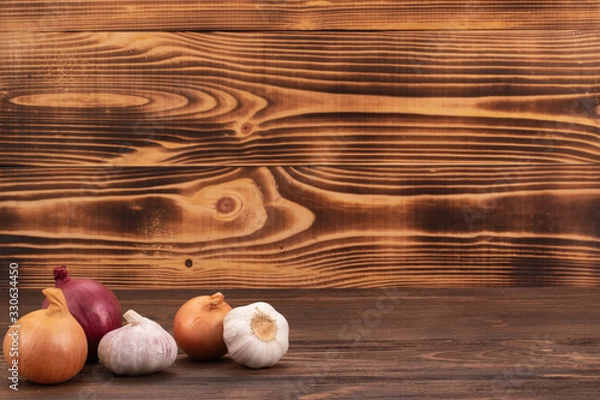 Fototapeta Fresh garlic and onion on wooden table with copy space, close-up