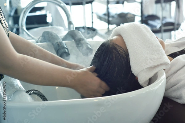Fototapeta Hairdresser in beauty salon massage head customer and hair care in procedure of steaming water steam. Service steaming ozone in spa and salon shop.