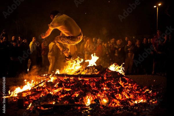 Fototapeta Jóvenes saltando el fuego en las hogueras de San Juan en Pamplona