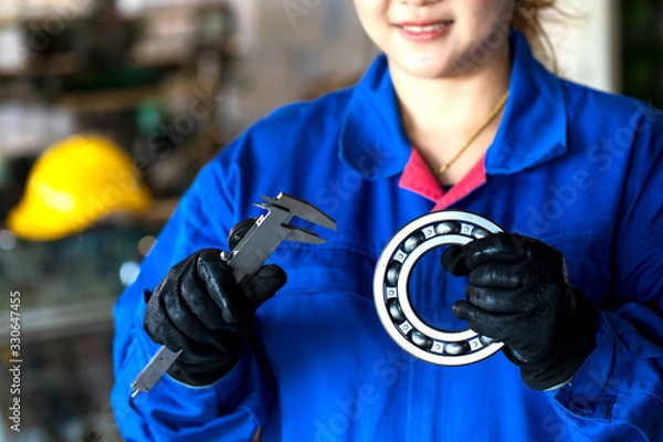 Fototapeta Femal technician hand holding ball bearing and vernier caliper tools..