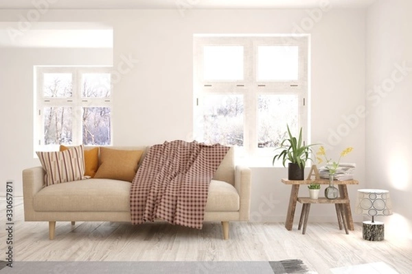 Fototapeta Modern living room in white color with sofa and winter landscape in window. Scandinavian interior design. 3D illustration