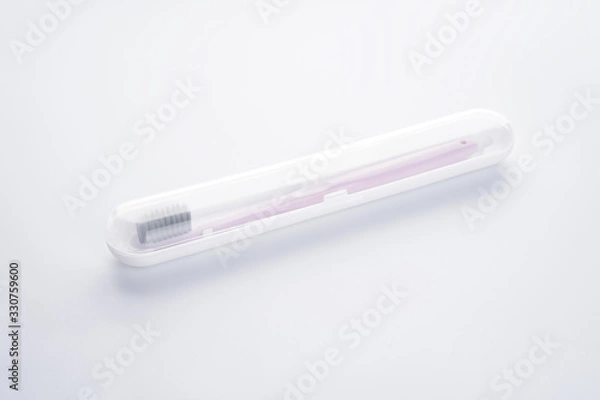 Obraz Pink toothbrush with black shield in a white case on a white background, isolated.