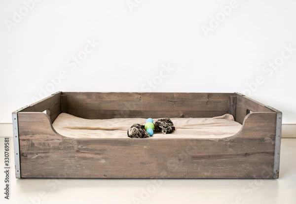 Fototapeta wooden dog basket. Bed for a dog made from wood. with a dog toy.
