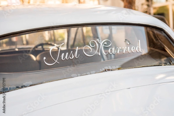Fototapeta Bullet holes in car windshield with Just Married sign for newlyweds