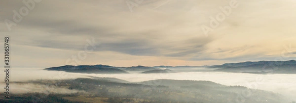 Fototapeta Fog in mountains before sunrise, mountain valley with clouds. View to mountains of the Carpathians