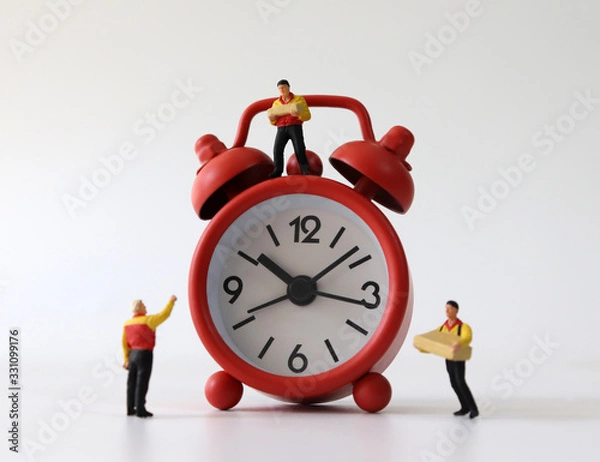 Fototapeta Red alarm clocks and miniature couriers.