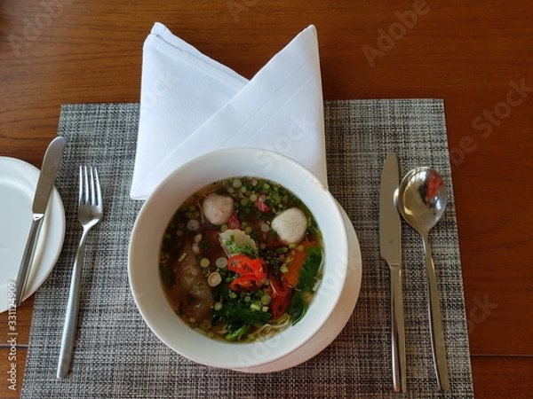 Obraz Top view of noddles, fish balls, vegetables and hot soup in a bowl.  Nutriuous food concept.