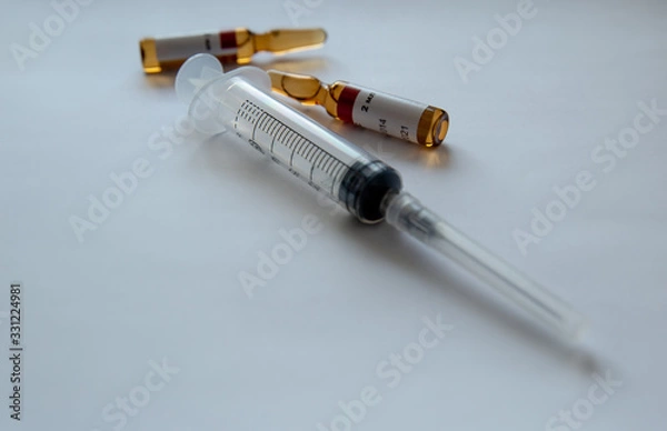 Obraz ampoules and syringe on a white background