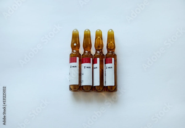 Obraz four brown ampoules on a white background