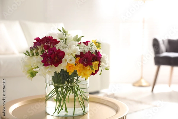 Fototapeta Beautiful bouquet with spring freesia flowers in light room, space for text