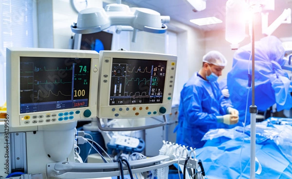 Fototapeta Ecg patient's condition on the monitor in operating room. Surgeon performing operation in operation theater.