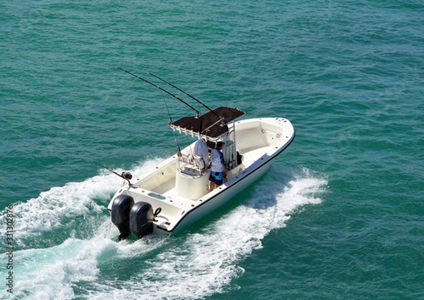 Fototapeta Angled overhead view of an open sport fishing boat with a black canvas canopied center console powered by two outboard meninges.