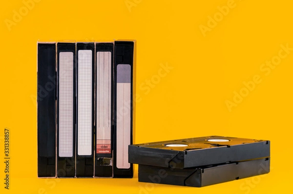 Fototapeta Old VHS video tapes isolated on yellow color background. Copy space for text. Old popular video technology from 1980s.
