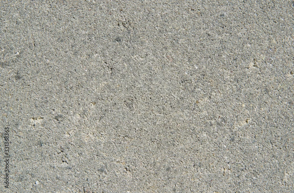 Fototapeta Light gray sand texture. Background with small interspersed grains of sand grains close-up. Rough concrete surface