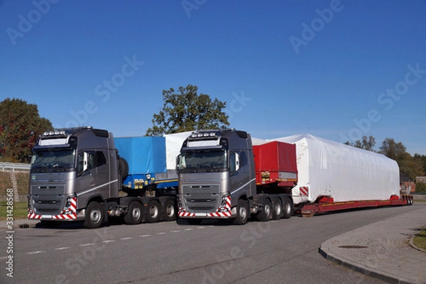 Fototapeta Oversize Load or exceptional convoy. A truck with a special semi-trailer for transporting oversized loads.