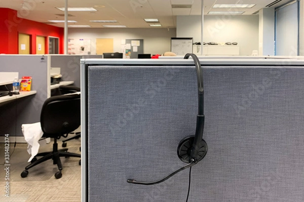 Fototapeta headphone hanging on cubicle wall in a call center 