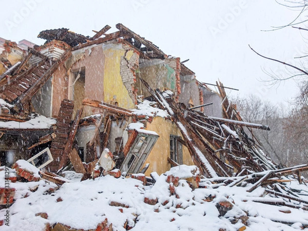 Obraz Destroyed old brick house in a snowfall