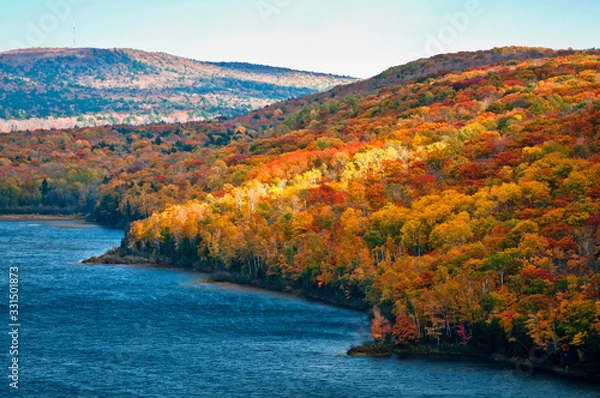 Obraz Shafts of sunlight play across the fall colors on the shore of Lake of the Clouds in the Porcupine Mountains Wilderness State Park, Michigan.