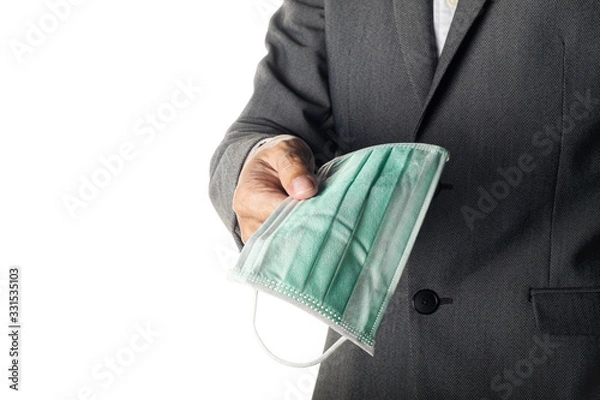 Obraz Man in gray suit holding face mask